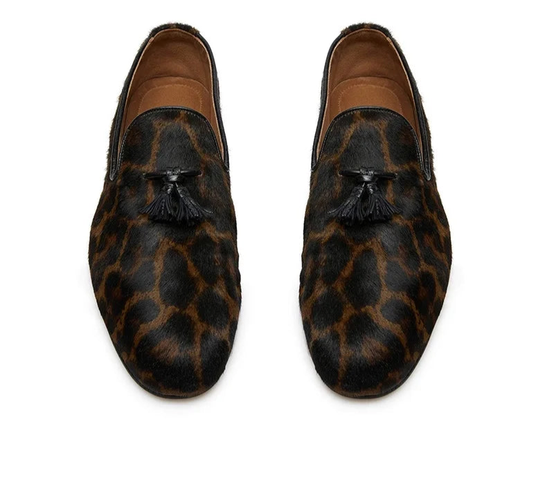 Pair of leopard print loafers with tassels on a white background