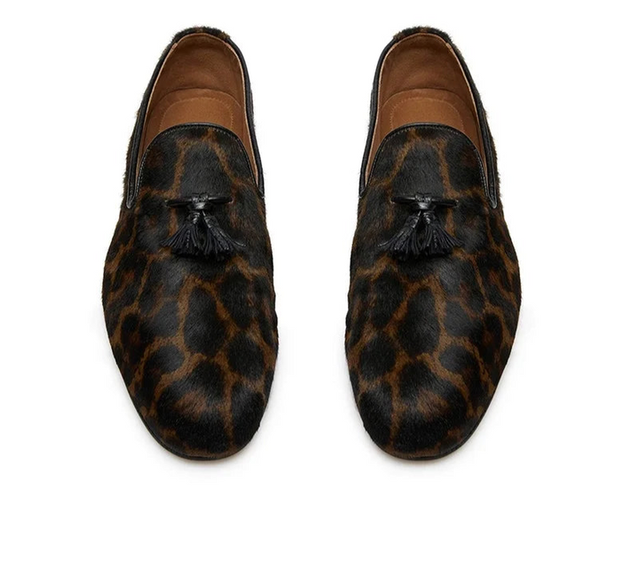 Pair of leopard print loafers with tassels on a white background
