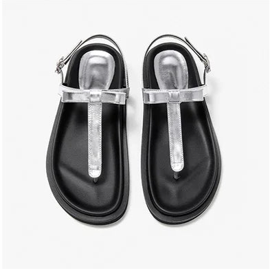 Black sandals with silver straps on a white background