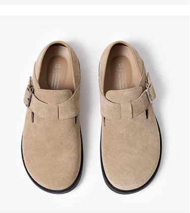 Pair of beige shoes with buckles on a white background