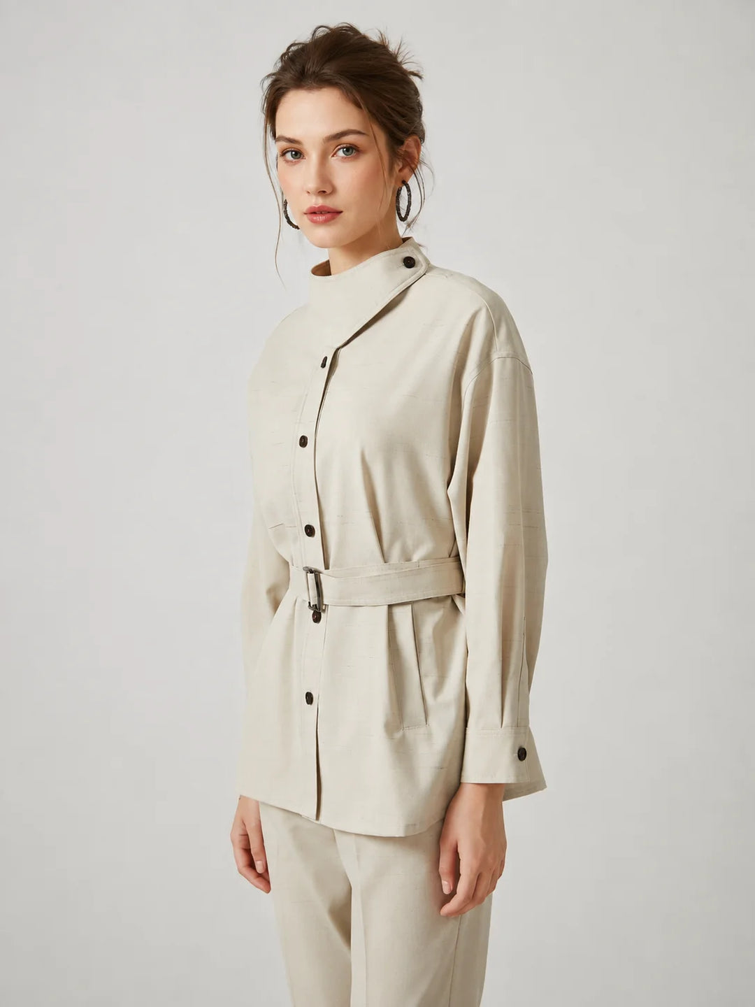 Wool slim trench coat in light cream, side view, button placket and tied belt.