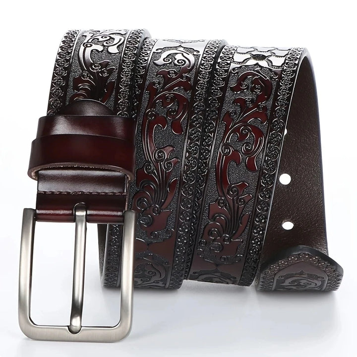 Brown leather belt with intricate silver buckle on a white background