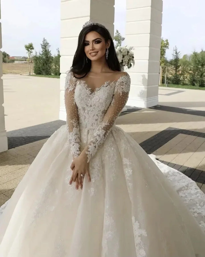 White lace bridal ball gown with beaded bodice, off-shoulder sleeves, and full skirt
