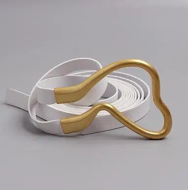 Wide belt with gold-tone heart buckle and light gold leather strap, laid on white box