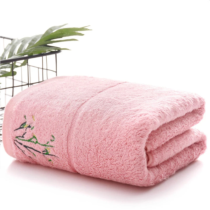 Thick bamboo-fiber bath towel set in pink, folded with embroidered bamboo leaf