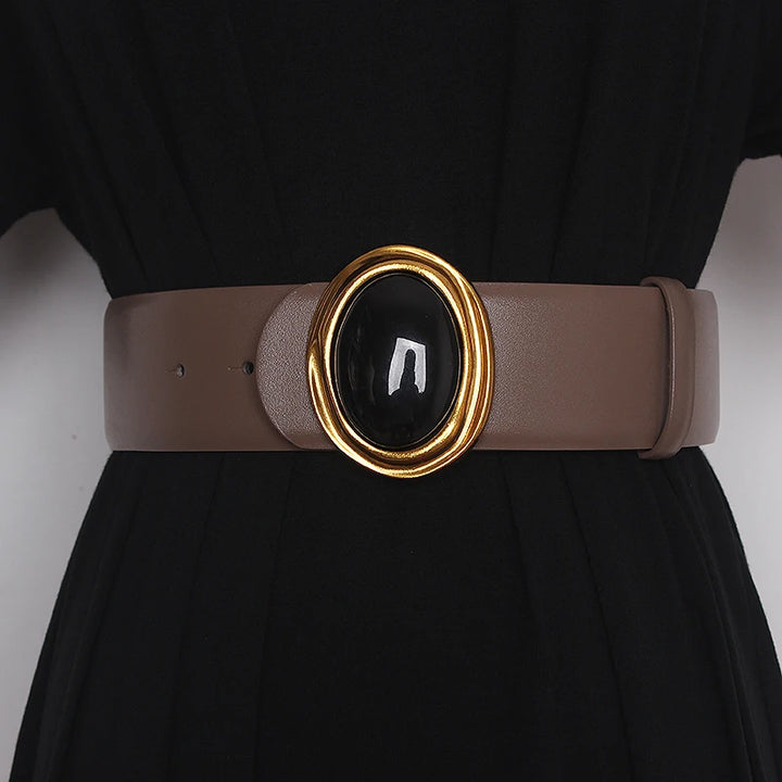 Wide leather belt in light brown with oval black center buckle and gold-tone ring hardware