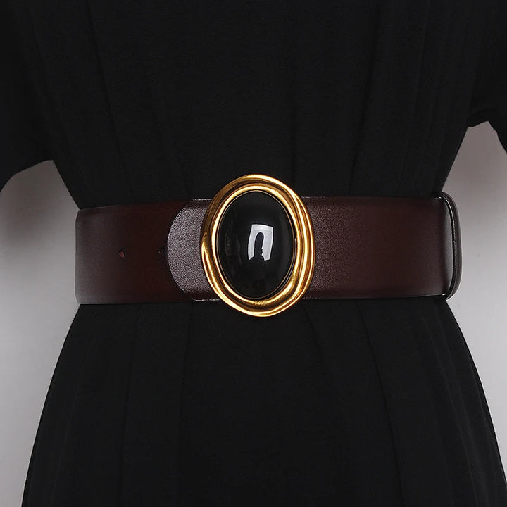 Wide leather belt in dark brown with oval black center buckle and gold-tone ring hardware