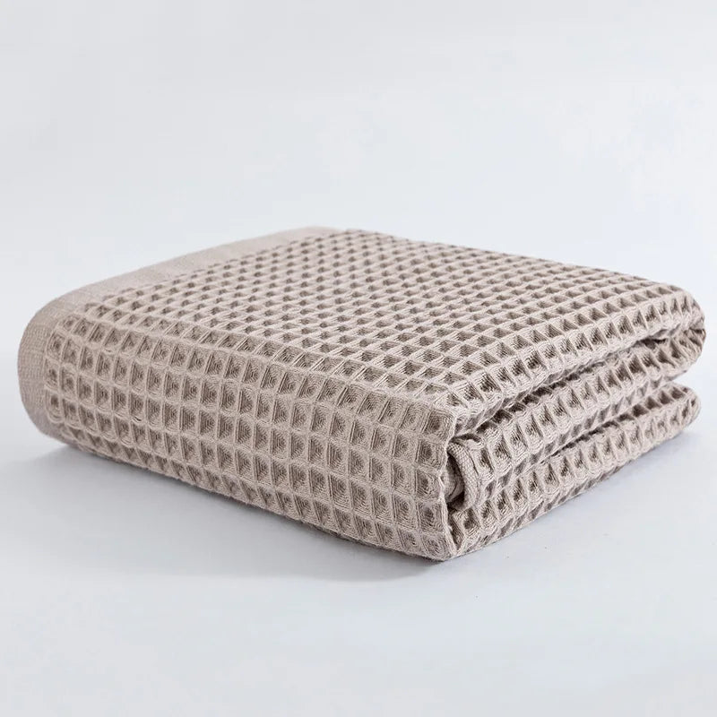 Soft cotton towel set, folded waffle-texture towels in taupe brown