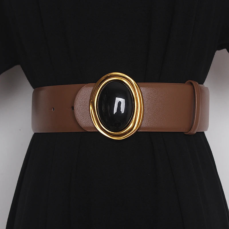 Wide leather belt in brown with oval black center buckle and gold-tone ring hardware