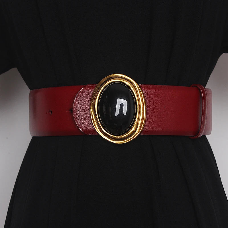 Wide leather belt in red with oval black center buckle and gold-tone ring hardware