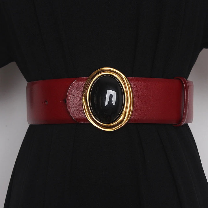 Wide leather belt in red with oval black center buckle and gold-tone ring hardware