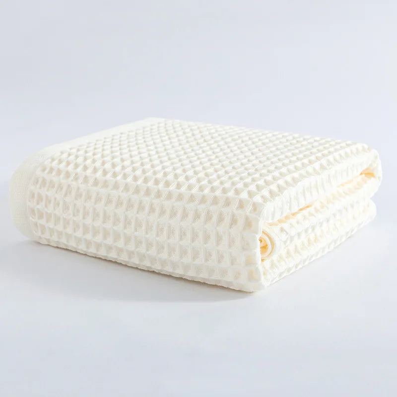 Soft cotton towel set, folded waffle-texture towels in off-white cream