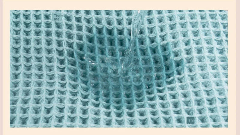 Waffle knit cotton towel with textured grid pattern in light teal close-up