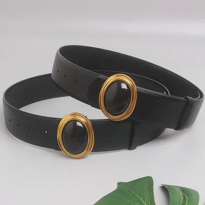 Wide black leather belts with oval gold-ring buckle and dark center, shown in pairs