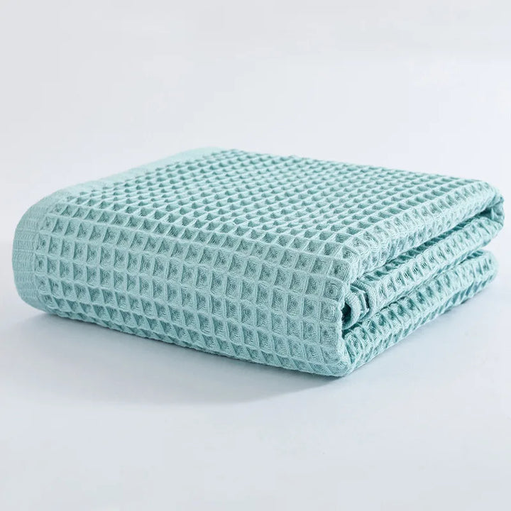 Light blue waffle-knit cotton towel folded stack