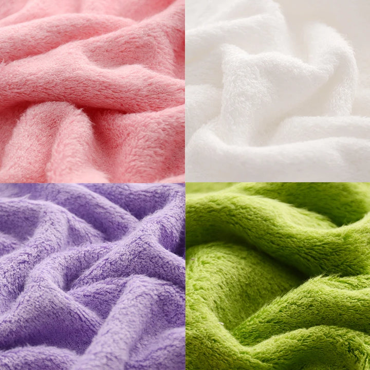 Bath towel fabric close-up showing folded textures in pink, white, purple, and green
