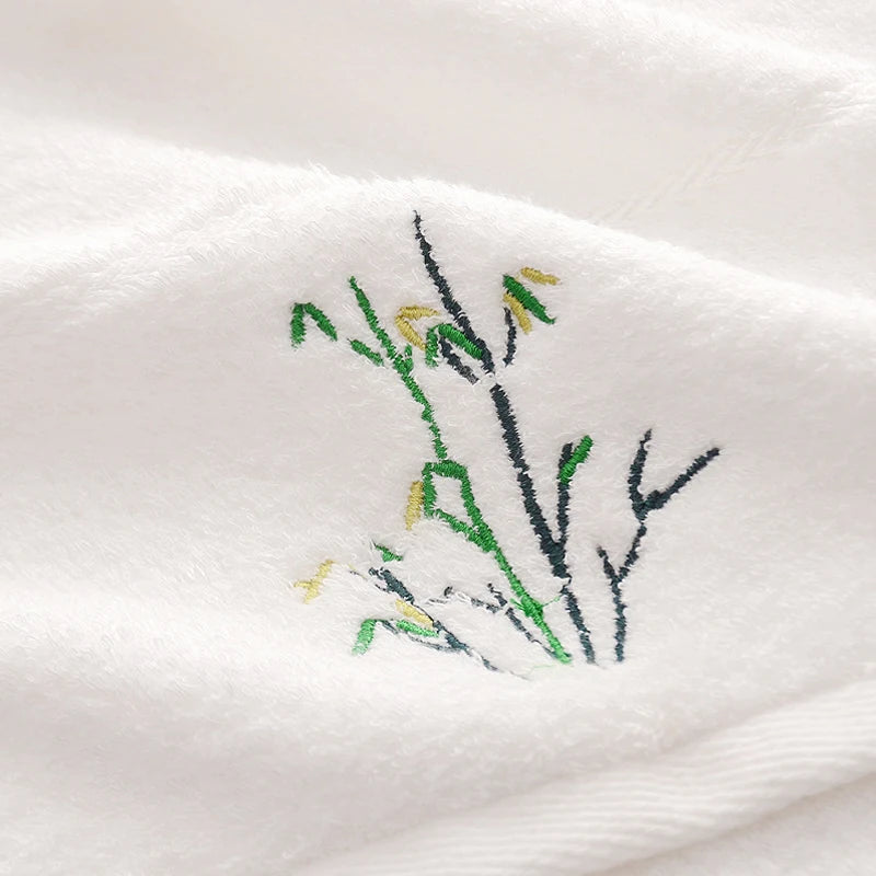 White bamboo-fiber towel close-up with embroidered bamboo leaf