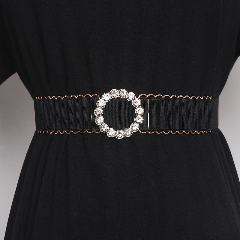 Black women's elastic belt with round rhinestone buckle and gold-toned ring detailing