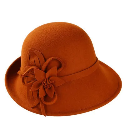 Rust red wool pillbox hat with layered fabric flower and side bow trim