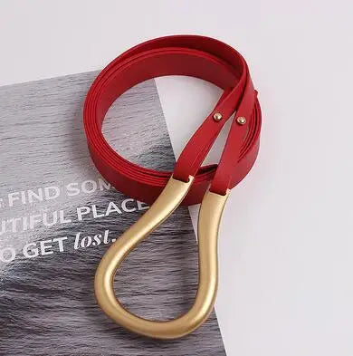Wide belt with gold-tone heart buckle and red leather strap, metal eyelets