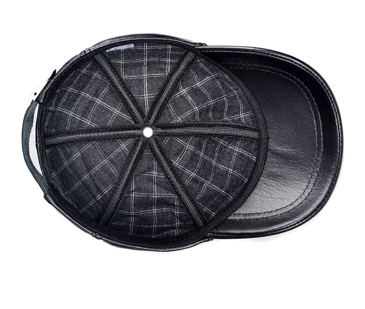 Leather cap with plaid fabric underside around the crown and inner brim