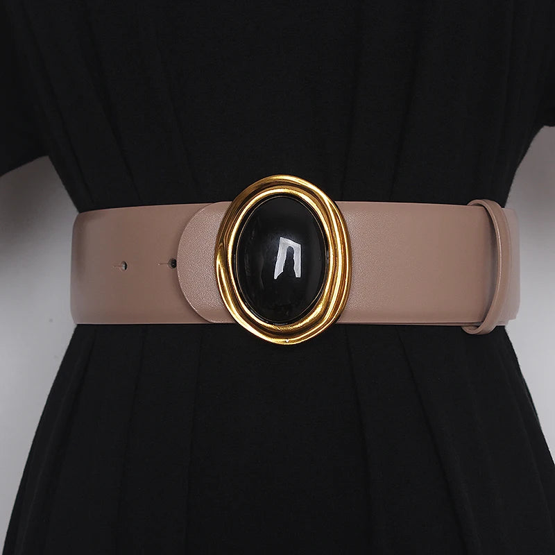 Wide leather belt in light beige with oval black center buckle and gold-tone ring hardware