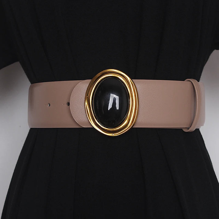 Wide leather belt in light beige with oval black center buckle and gold-tone ring hardware