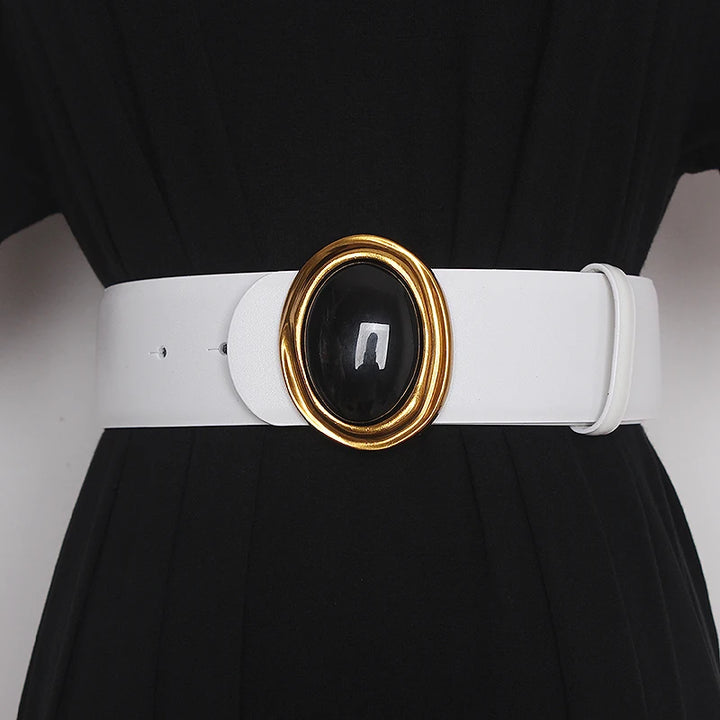 Wide leather belt in white with oval black center buckle and gold-tone ring hardware