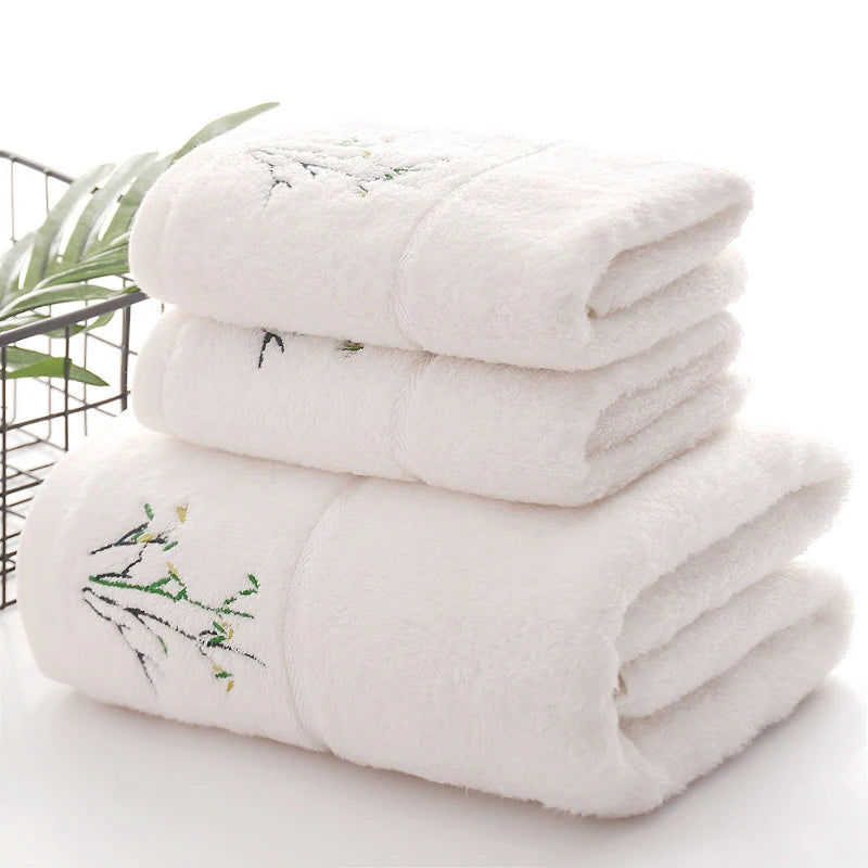Thick white bamboo-fiber bath towel set, folded with embroidered bamboo leaf