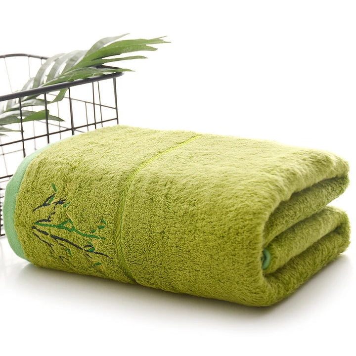 Thick bamboo-fiber bath towel set in lime green, folded with embroidered bamboo leaf