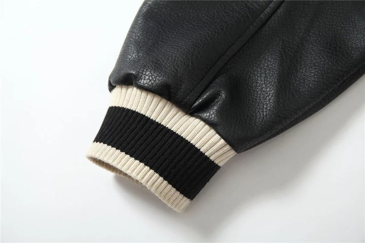 Black leather-look sleeve cuff with cream-and-black ribbed knit trim