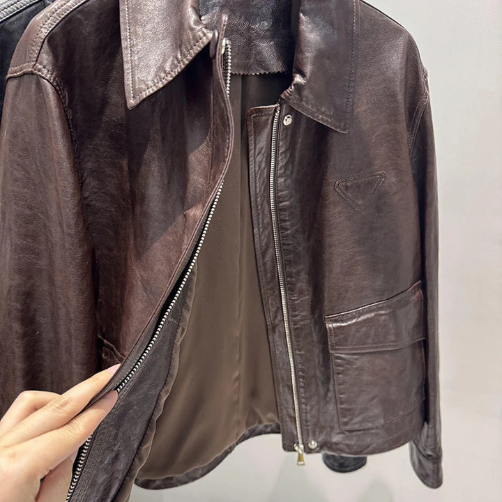 Close-up of women’s distressed leather jacket: front zipper, notch lapel, chest pocket