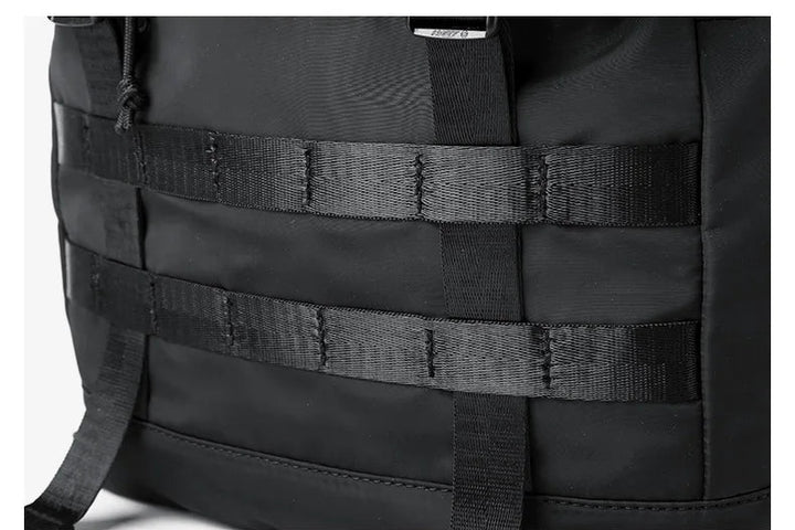 Black expandable roll-top rucksack with multifunction front strap webbing