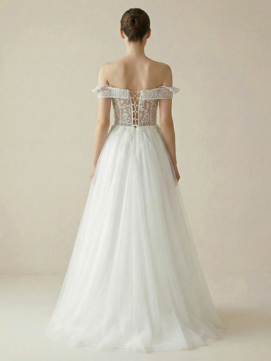 White bridal gown with A-line silhouette, lace backless bodice and off-shoulder sleeves