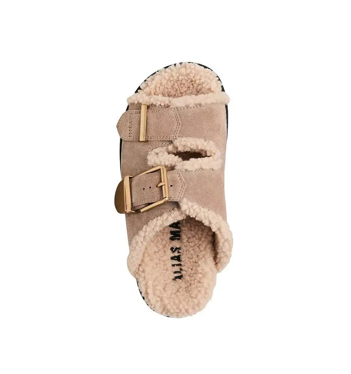 Dog boot with fur lining and buckle on a white background