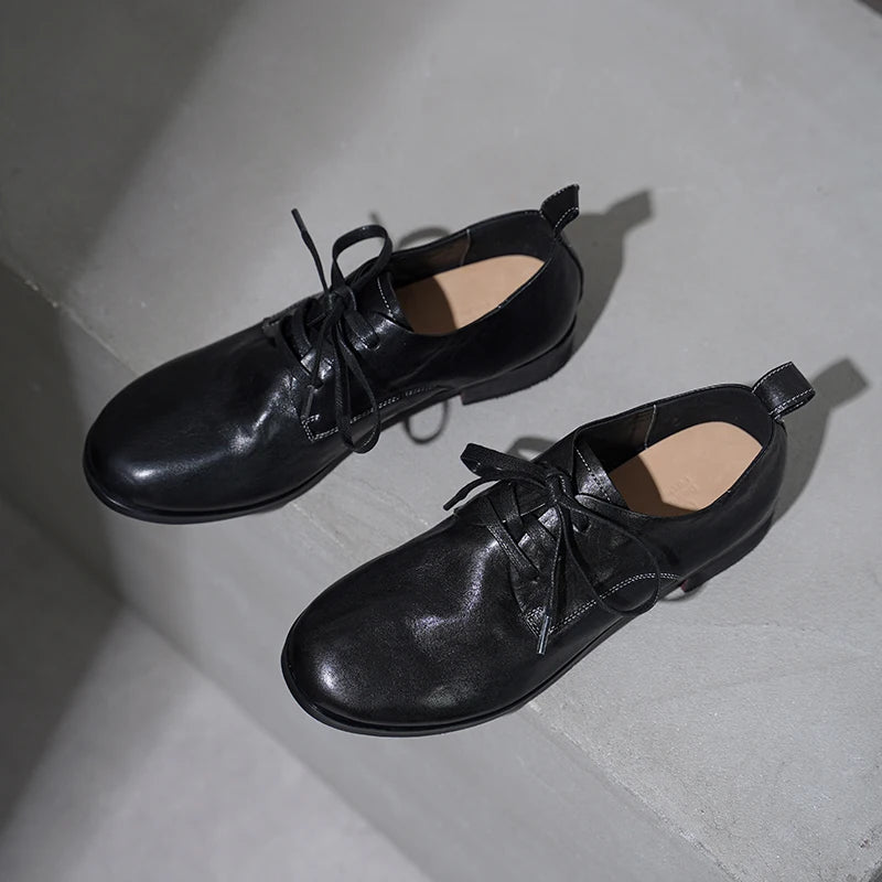 Black lace-up leather flat shoes with low heel and rounded toe