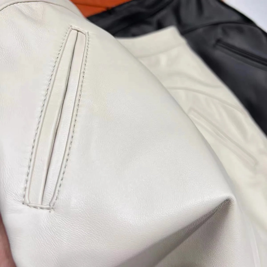 White leather mini skirt close-up showing stitched panel and textured finish