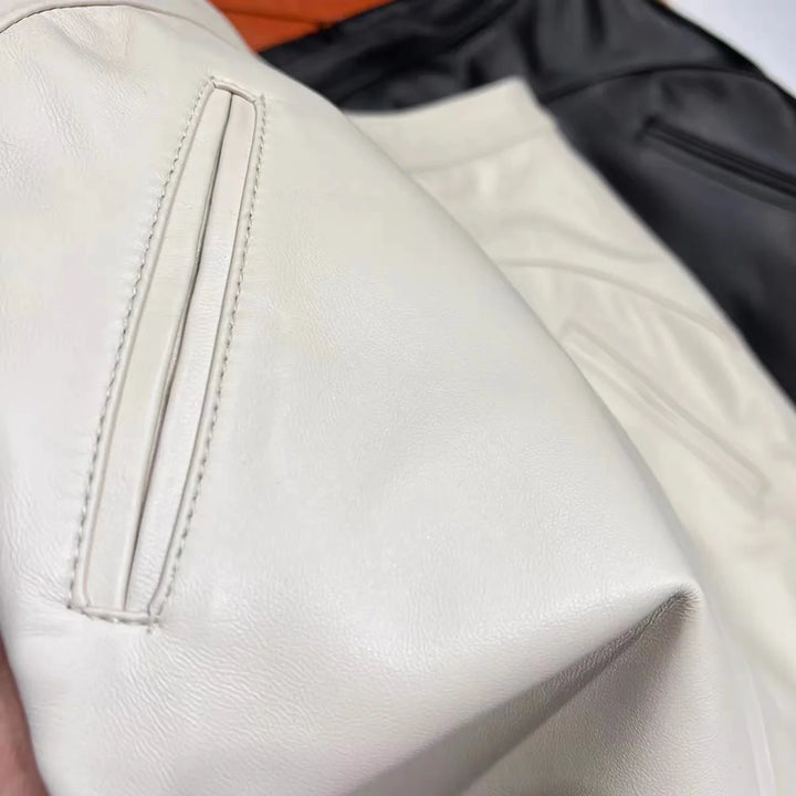 White leather mini skirt close-up showing stitched panel and textured finish