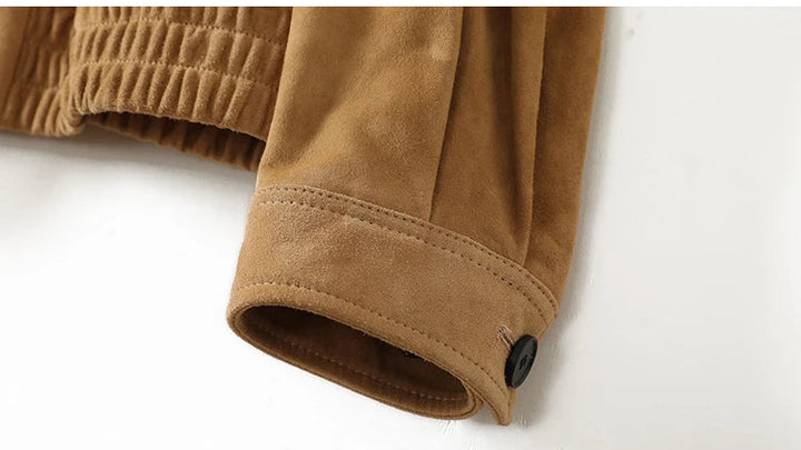 Tan suede jacket cuff with elastic trim and snap button detail at hem opening.