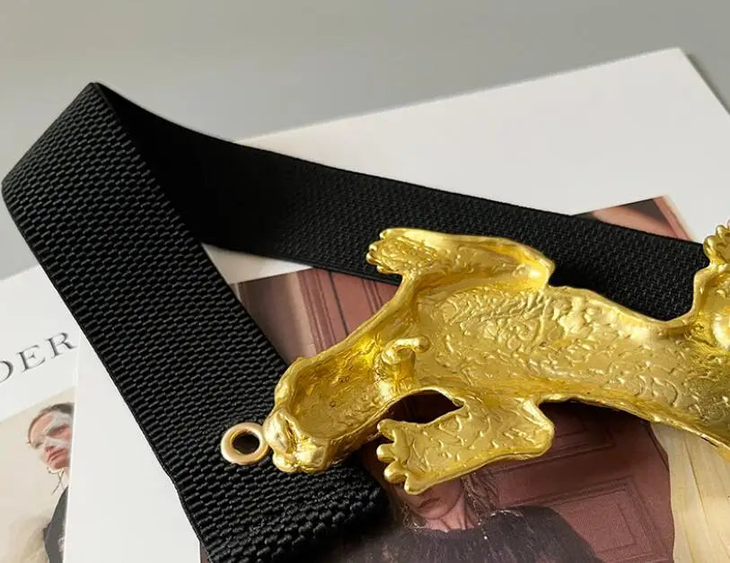Yellow leopard cat detail with textured black elastic belt strap, close-up view