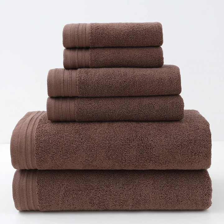 Dark brown cotton bath towel set, stacked rolled towels with solid terry texture