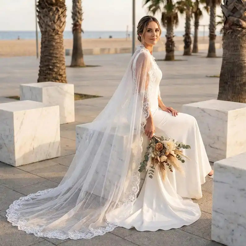 Ivory tulle bridal cape with lace edging and long train-style drape