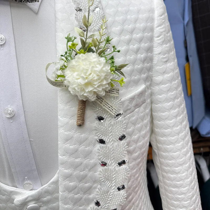 White floral boutonniere on a white textured jacket with a blurred background