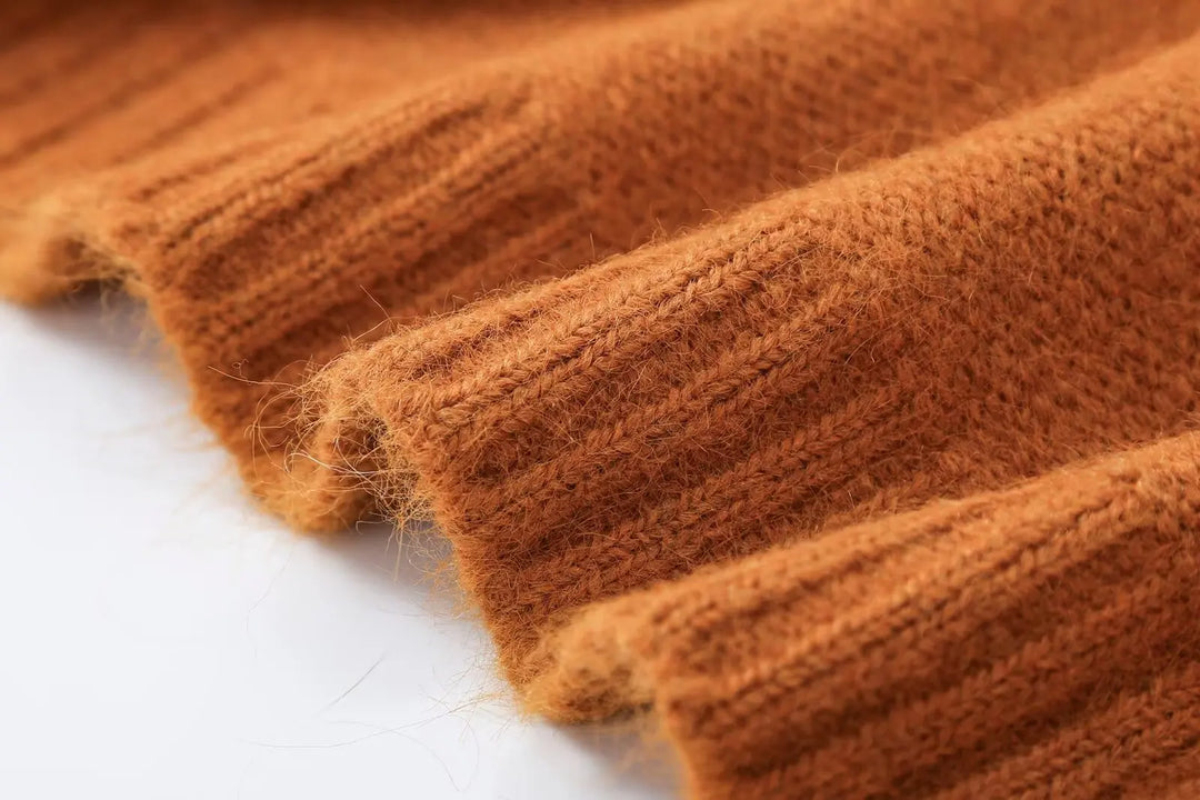 Orange knit cardigan sleeve cuff and ribbed hem texture close-up