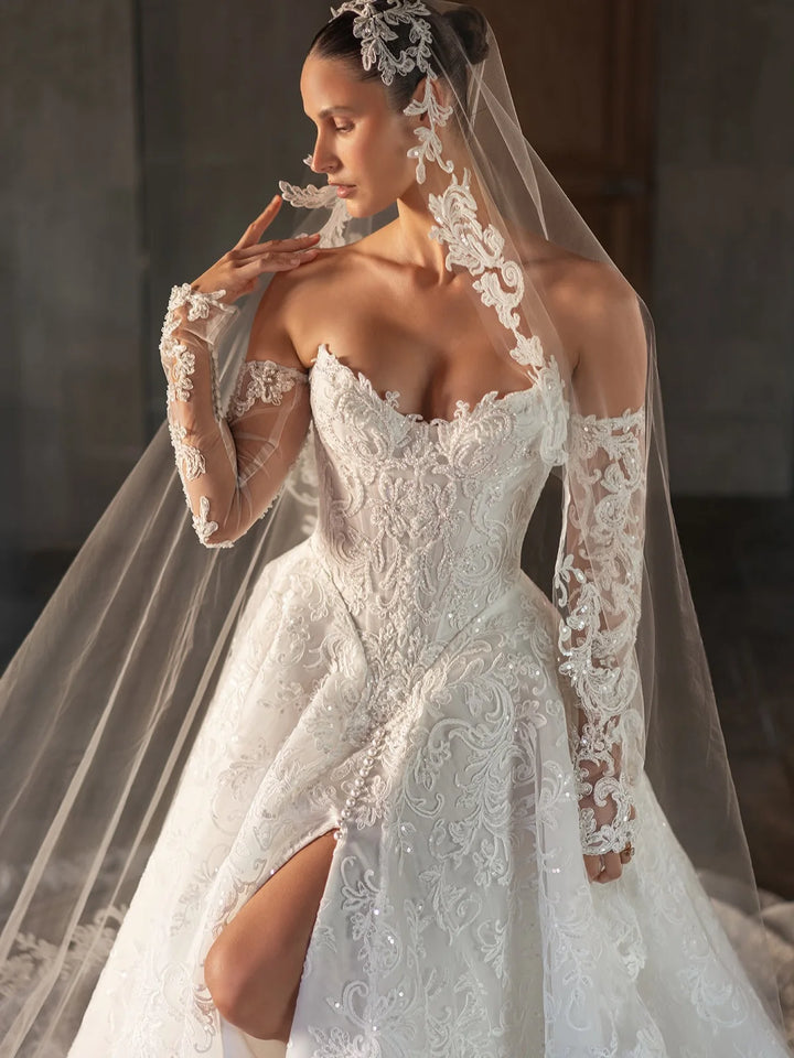 White bridal lace gown with sweetheart corset bodice, lace sleeves, high slit, veil