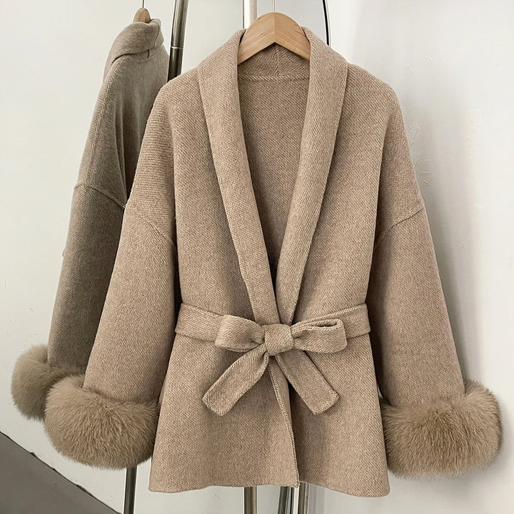 Beige taupe coat with faux fur trim on cuffs and collar, wide lapels, and waist tie belt