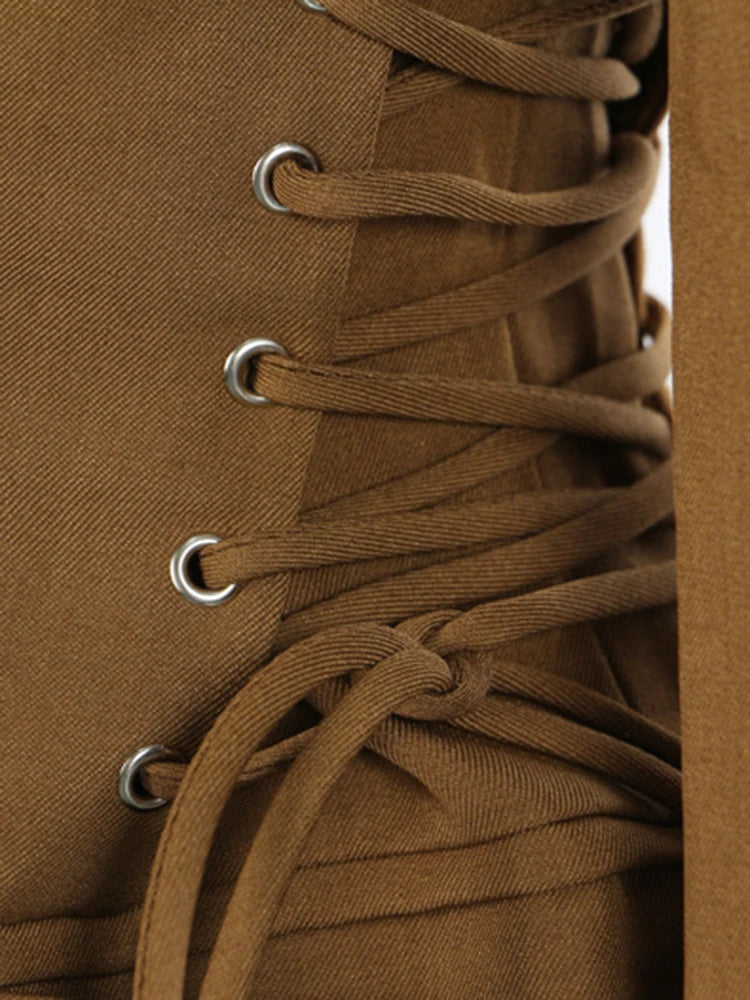Women’s blazer close-up: tan brown lace-up panel with metal grommets