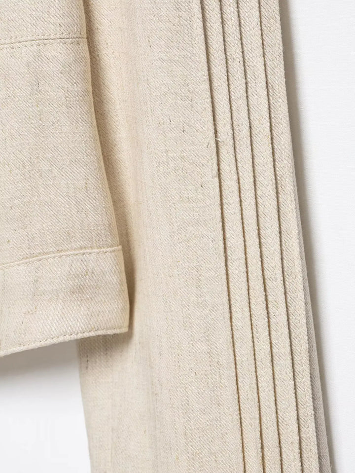 Beige cropped blazer sleeve and side panel with vertical pleated seaming