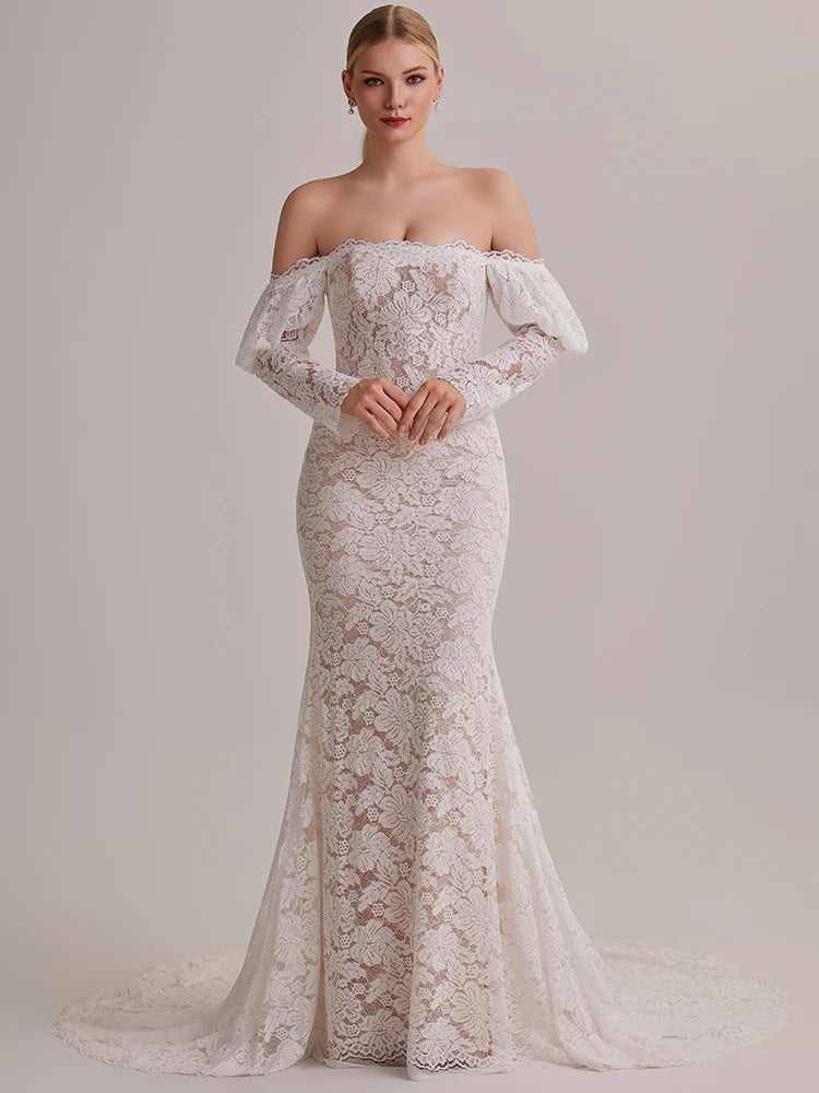 Woman wearing a white lace off-shoulder gown against a plain background