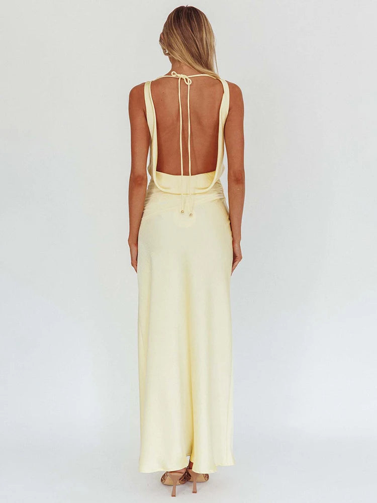 Back view of light yellow satin maxi dress with open-back straps and draped bodice